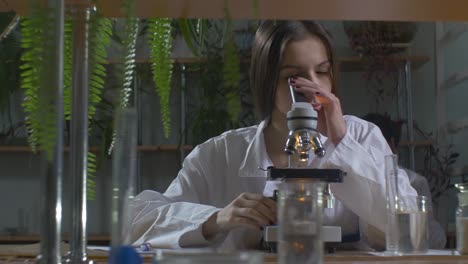 scientist examining sample under microscope in a laboratory