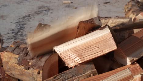 Split-logs-falling-down-on-woodpile,-firewood-production,-close-up-slow-motion