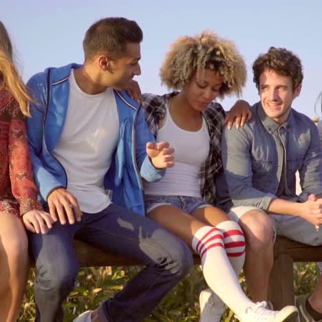 young people sitting on wooden fence