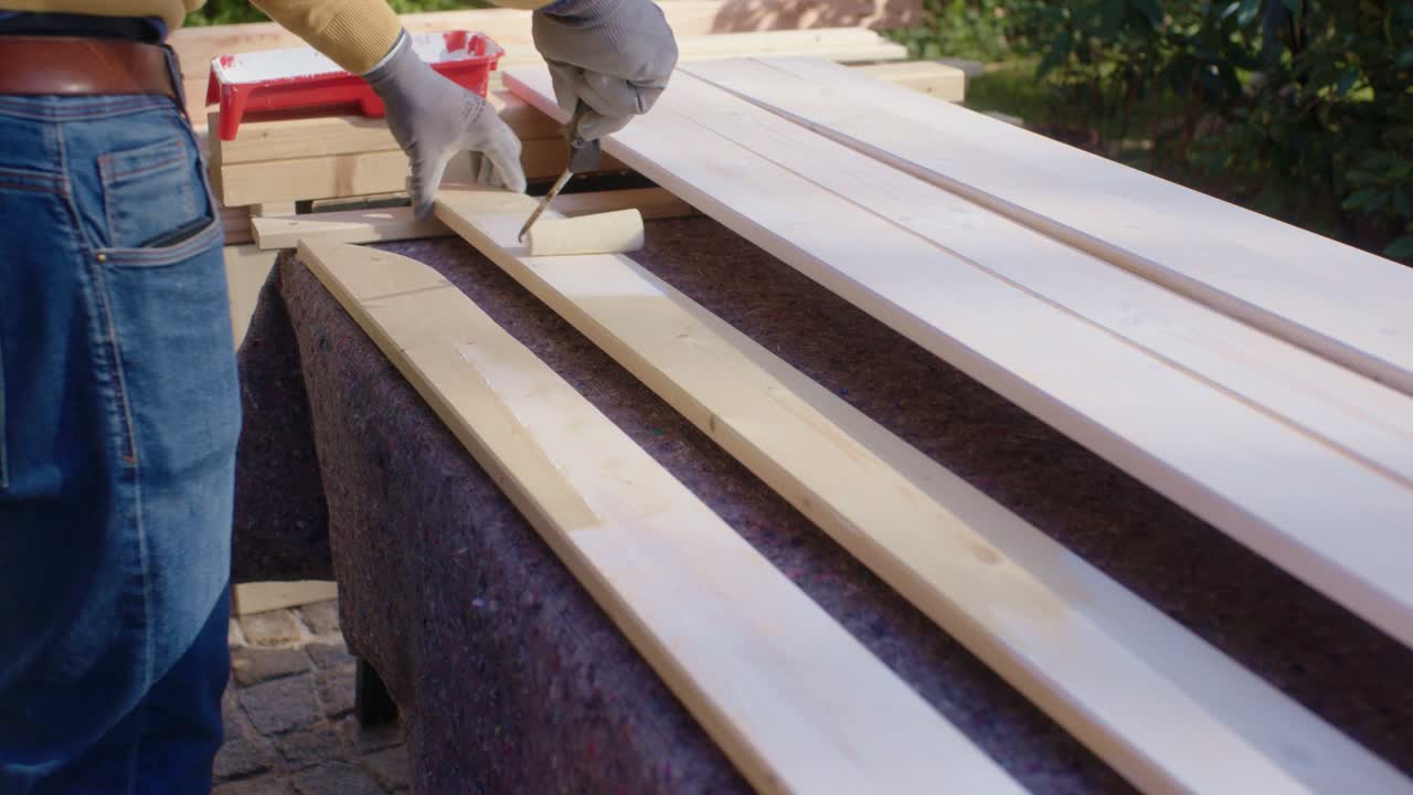 L'artigiano dipinge i pezzi di legno sul piano di lavoro