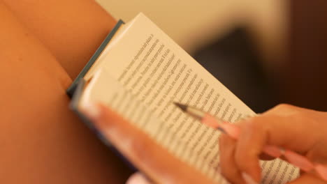 un primer plano de un libro abierto con las páginas ligeramente ventiladas, sostenido por una persona con un fondo borroso
