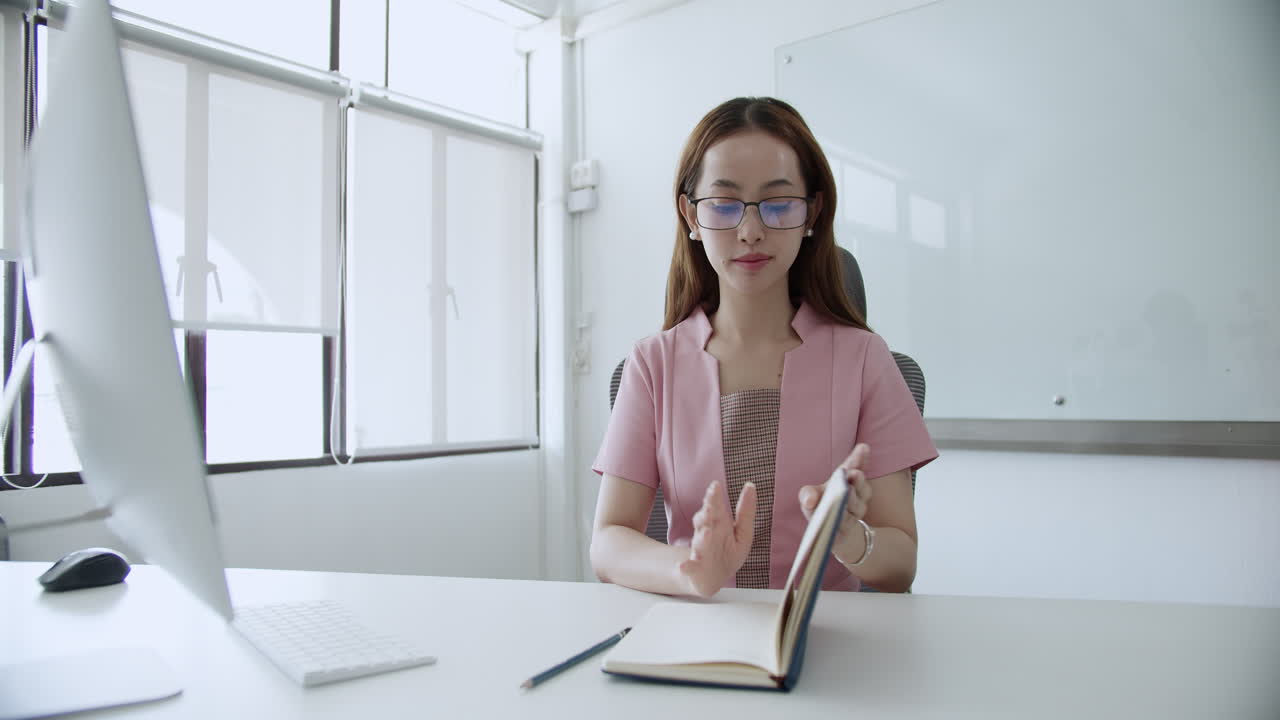 una trabajadora enfocada se involucra en tareas en su escritorio en una oficina moderna que ejemplifica la productividad.