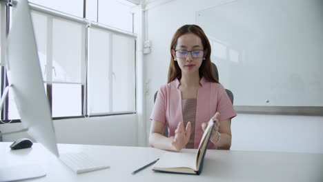 una trabajadora enfocada se involucra en tareas en su escritorio en una oficina moderna que ejemplifica la productividad.