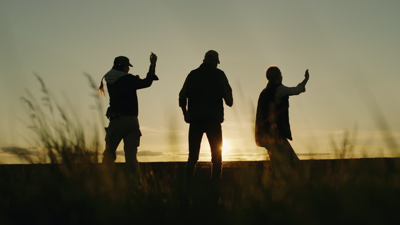 일몰 때 춤을 추는 사람들의 실루