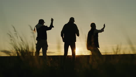 silhouette of people dancing at sunset