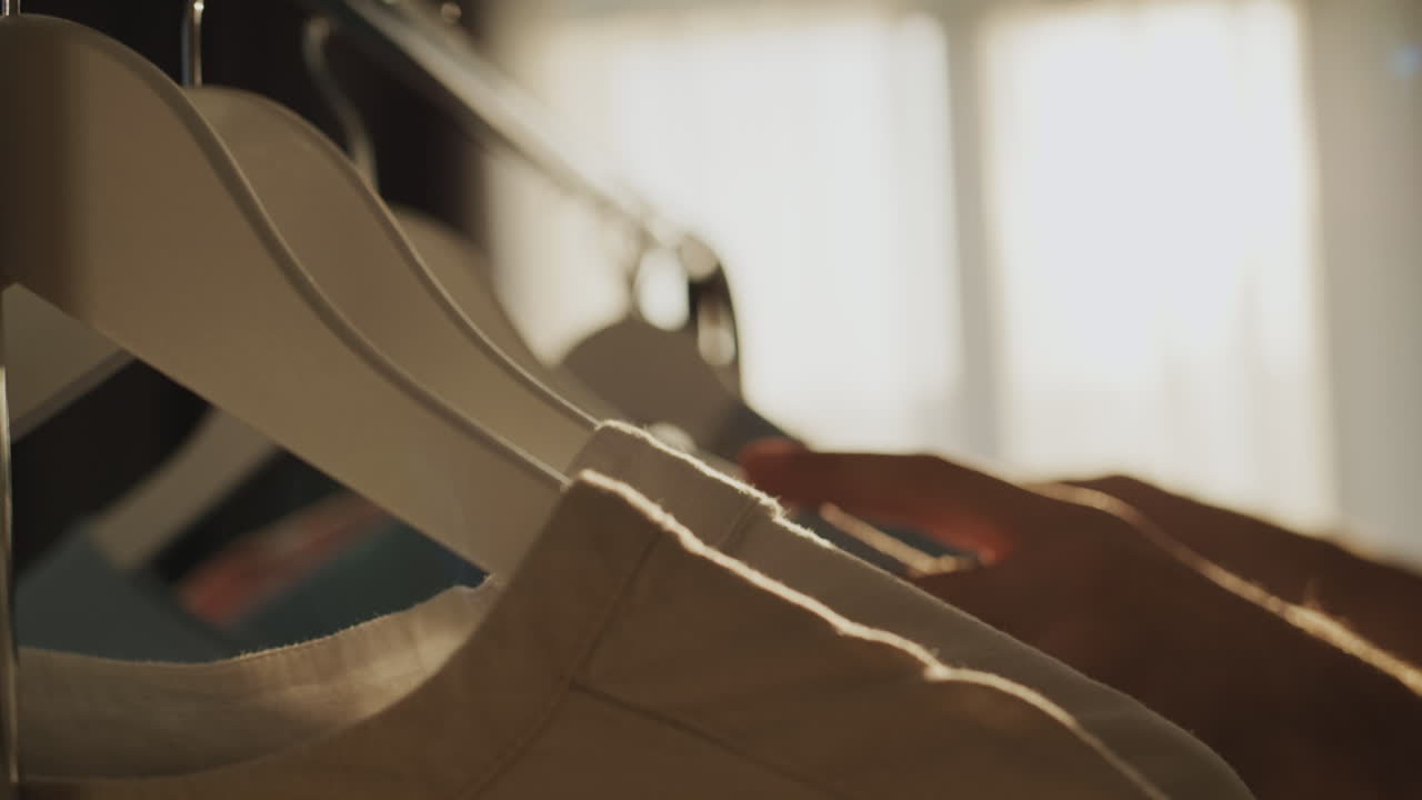 남성 의 손 은  ⁇ 어리 에 매달린 옷 을 선택 한다