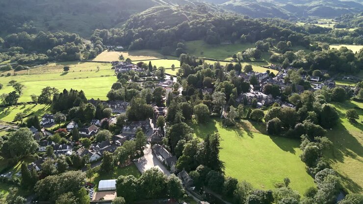 Aerial video footage Grasmere Village, Town in the Cumbrian Lake District National Park England UK on a beautiful summers evening