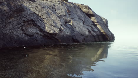 rocky cliff overlooking calm ocean water