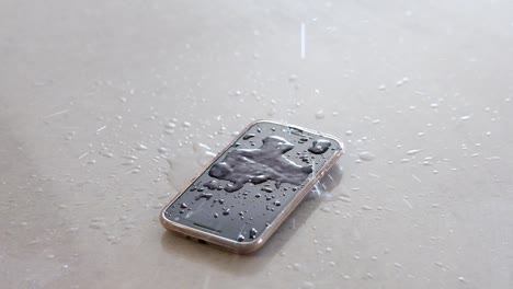 pouring water drops onto a mobile cell phone screen