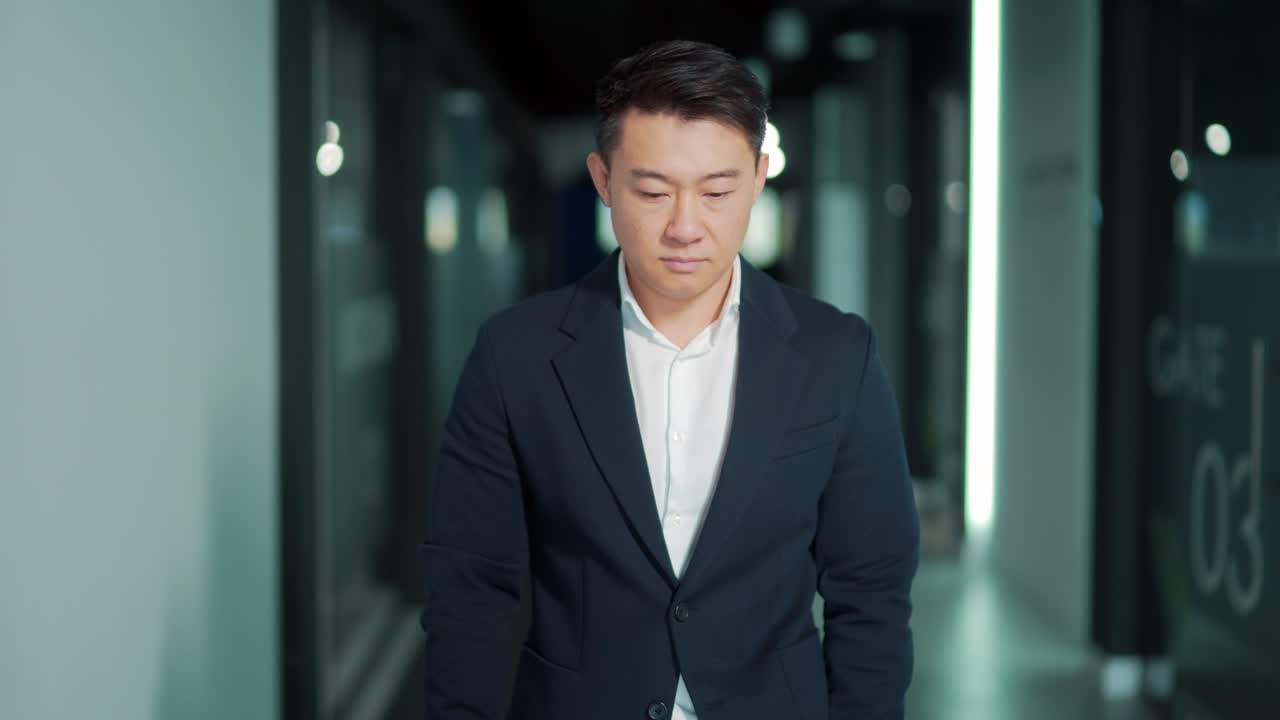 portrait of a successful confident asian male office worker standing and looking at the camera in a formal suit indoors. The face of a business man or entrepreneur employee