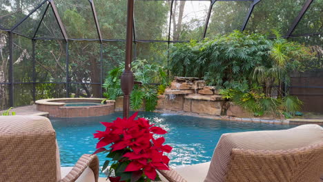 outdoor swimming pool with waterfall and bamboo inside screened in lanai porch