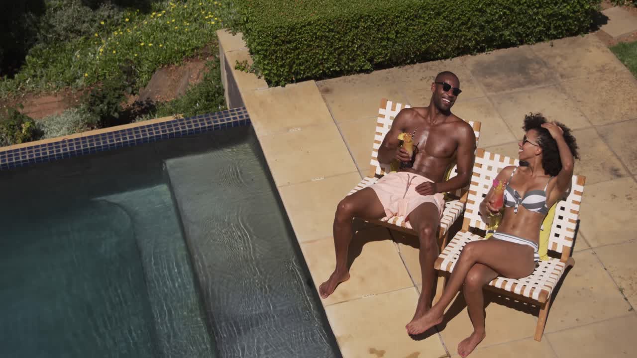 Happy mixed race couple enjoying the pool during a sunny day