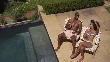 Happy-mixed-race-couple-enjoying-the-pool-during-a-sunny-day