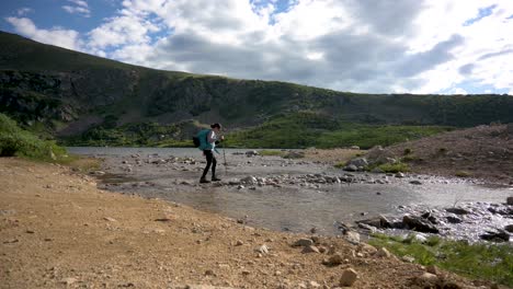 Female-hiker-crossing-Rocky-Mountain-stream-in-Loch-Lomond-Lake-in-Colorado