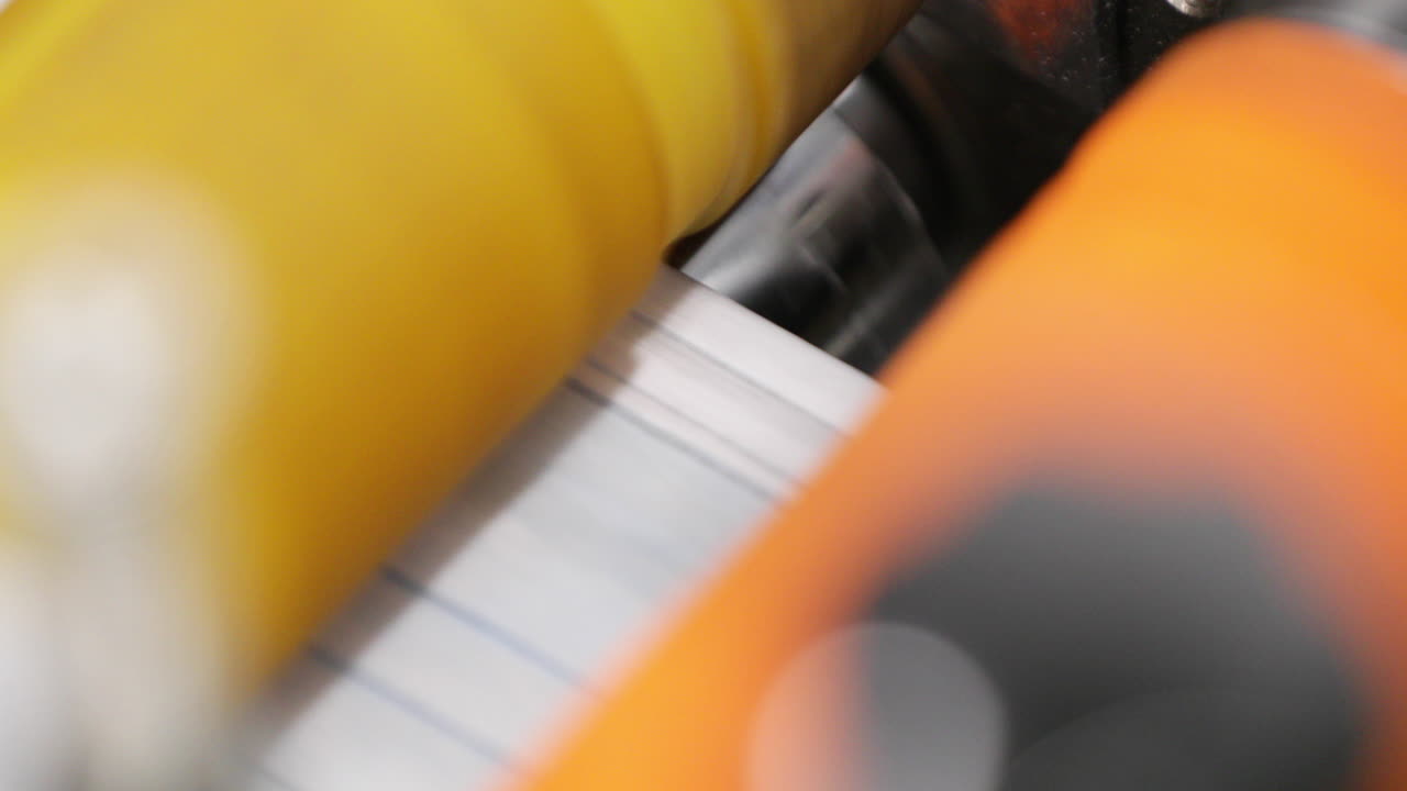 Rolos de máquina automática de alta velocidade selando os lados de máscaras cirúrgicas em oficina de fábrica.