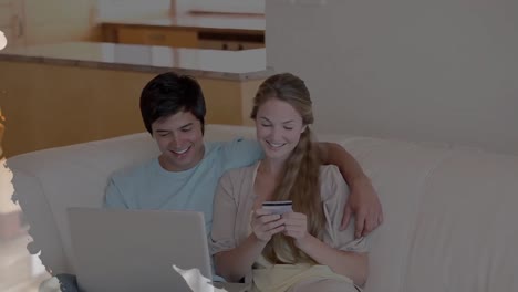 animation of shapes over diverse couple using laptop for online shopping