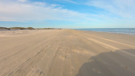 pov while slowly driving vehicle on the beach near the dunes at north padre island national seashore near corpus christi texas usa