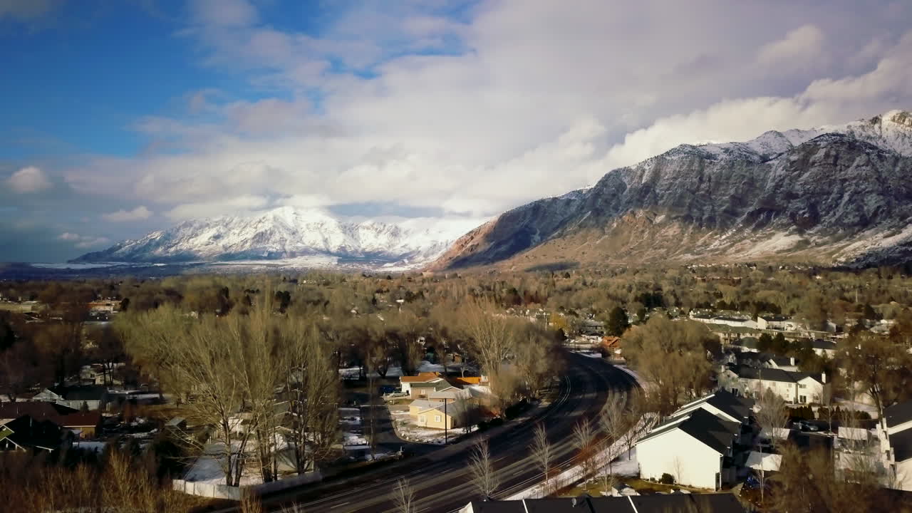 Panoramica verso l'alto: autostrada, Monte Ben Lomond, Ogden, SLC, Utah, pomeriggio, auto blu, oro, gialle, quartiere, drone, metà inverno, febbraio 2019.