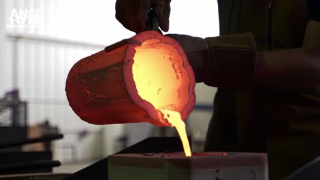 transforming molten metal: a skilled craftsperson pours glowing red liquid into a mold during a metal casting process in a modern foundry environment