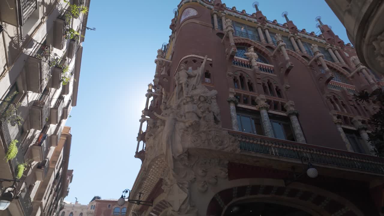 바르셀로나의 파라우 데 라 뮤직 카탈라나 (palau de la música catalana) 앞면의 건축적 세부 사항, 은 날 은 파란 하늘 아래 장식된 디자인과 조각을 특징으로합니다.