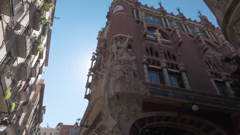 architectural details of the palau de la música catalana facade in barcelona, featuring ornate design and sculptures under a clear blue sky on a sunny day.
