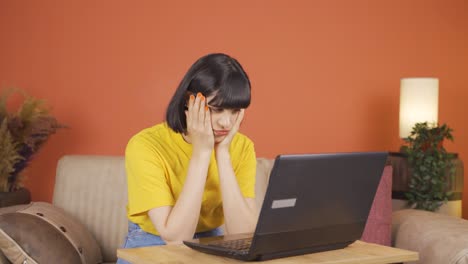 woman looking at laptop gets frustrated.