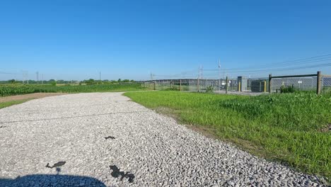 POV-pulling-away-from-a-gate-and-fence-around-a-large-number-of-solar-panels