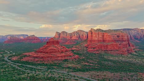 retiro aéreo por encima de la carretera en sedona arizona con torres de piedra arenisca iluminadas por luz dorada