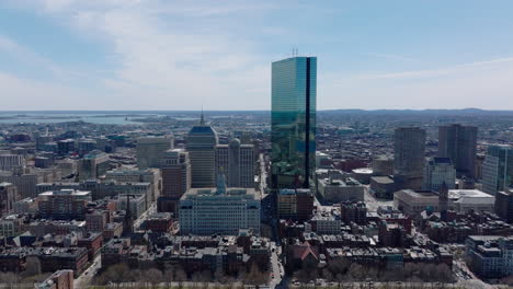 Forwards-fly-above-urban-borough.-Glossy-glass-facade-of-John-Hancock-Tower-reflecting-surroundings.-Boston,-USA