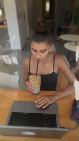 una mujer joven trabajando en un café.