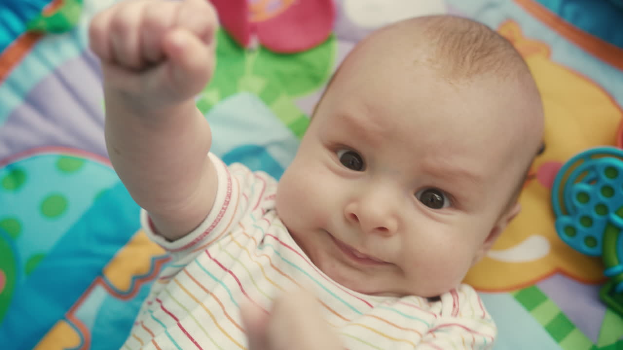 Portrait of infant looking at camera on colored mat. Close up of cute baby face