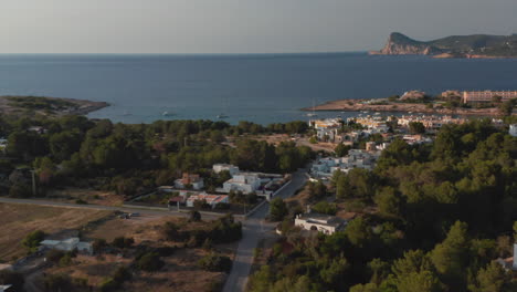 Establisher-shot-of-early-morning-view-of-empty-streets-with-beautiful-small-white-house-facing-towards-the-sea-and-mountain-in-Ibiza-in-Spain