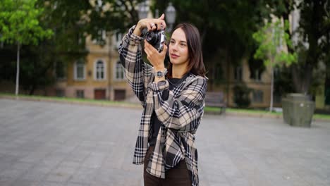 joven tomando fotos con una cámara vintage en la ciudad