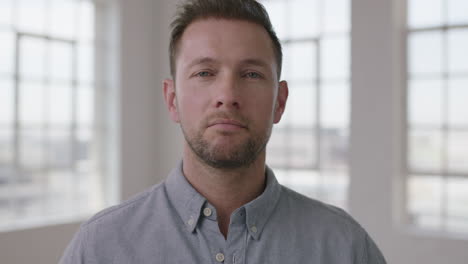 close up portrait of young caucasian man in empty apartment room looking confident at camera startup business idea