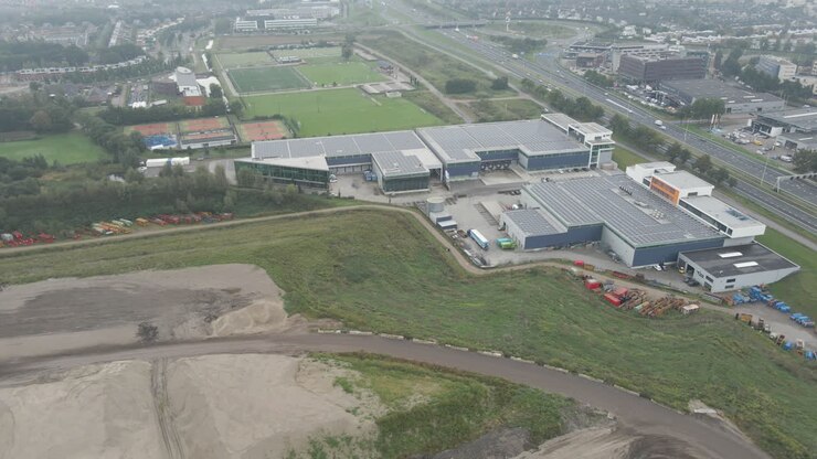 Luftfoto af stor industribygning med tag fyldt med solpaneler