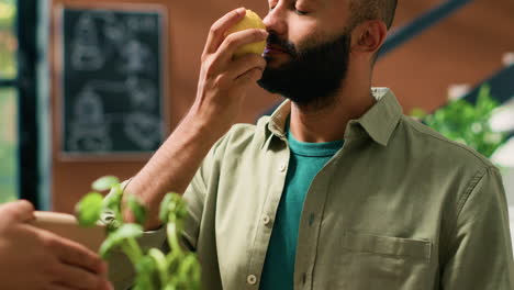 el dueño de la tienda da limones al cliente.