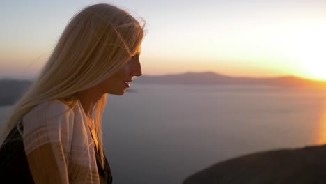 woman enjoying sunset in santorini, greece