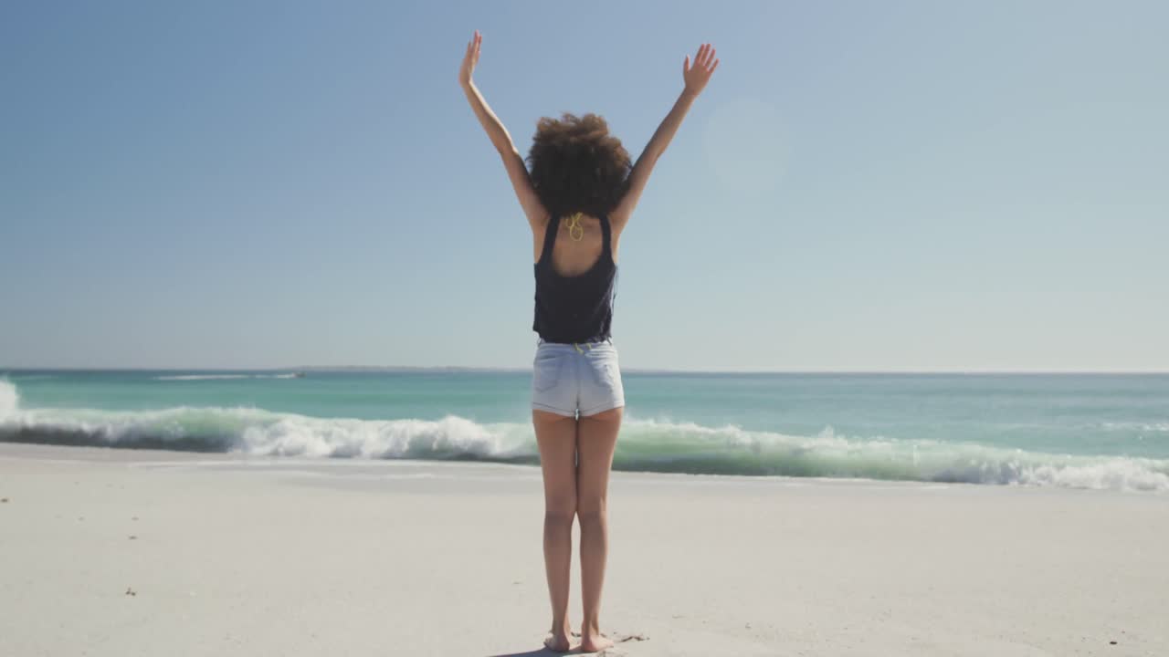 mujer de raza mixta disfrutando del aire fresco en la playa