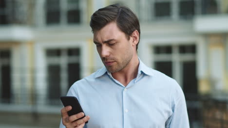 Hombre-De-Primer-Plano-Escribiendo-Por-Teléfono-En-La-Calle.-Empresario-Usando-Teléfono-Inteligente-Al-Aire-Libre