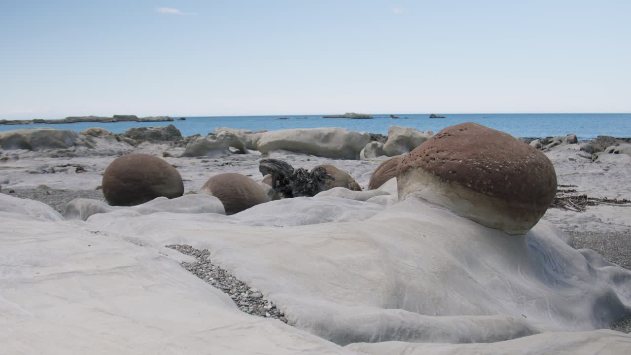 Round boulders sitting on Ward beach in New Zealand