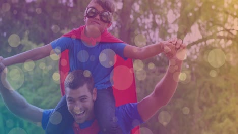 animación de bokeh sobre padre e hijo caucásicos felices en trajes de superhéroes