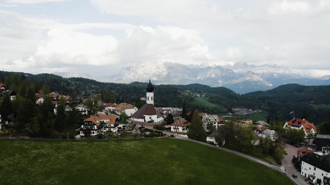 vista aérea empujando hacia la iglesia de la ciudad en oberbozen, italia