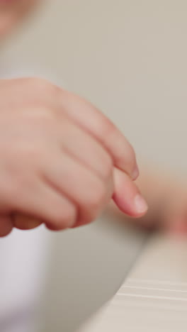 little girl plays piano music with toddler boy index finger on blurry background closeup. elder sister learns composition with brother on musical instrument