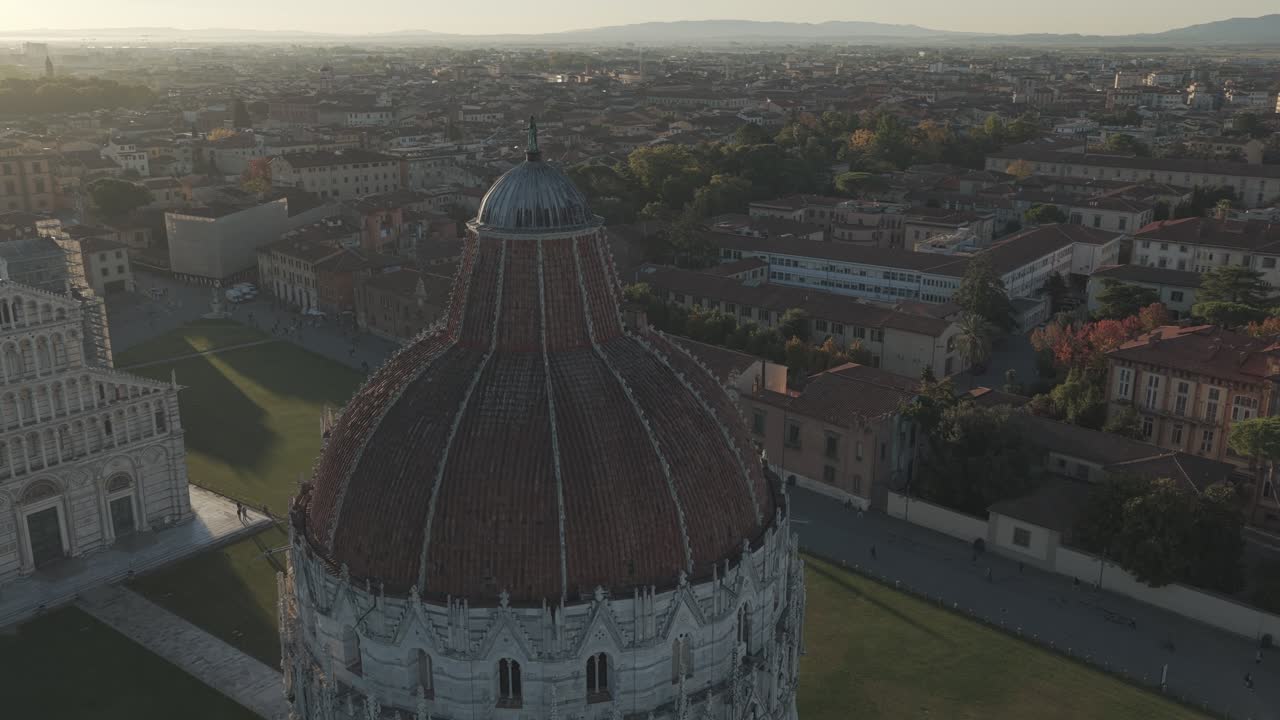 Cinematic sunrise drone footage of the Leaning Tower of Pisa and the Piazza dei Miracoli, captured with smooth aerial movements and soft early morning light