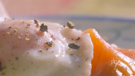 extreme close up details of smoked salmon topped with peppered poached egg. morning breakfast high protein healthy stylish food brunch footage 4k.