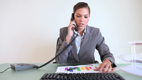 una mujer de negocios seria hablando por teléfono.