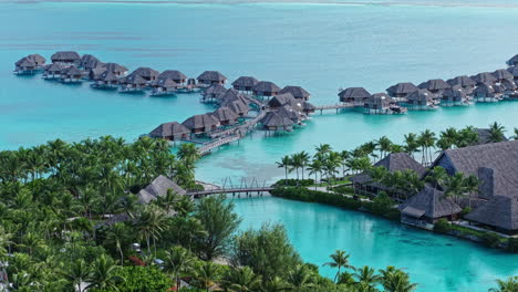 bora bora, french polynesia. drone view of overwater bungalows in turquoise lagoon water