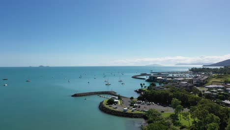 aerial drone shot over airlie beach, queensland - showing marina area, yachts and boats on bright sunny day.