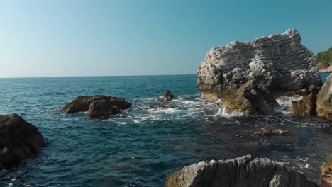 Close-to-water-drone-shot-between-cliffs-and-rocks-near-seashore