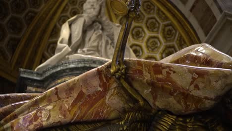 skeleton arm holding an hourglass in front of the statue of a priest in the vatican, rome